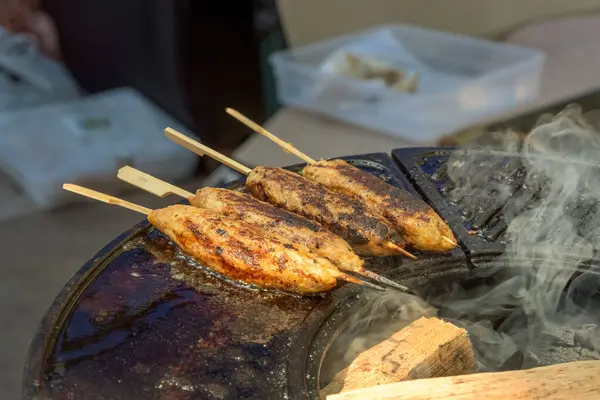 切碎的肉片 在街头快餐店的烤架上 用煤块烤制在木制绞架上的烤肉串 后续行动 — 图库照片