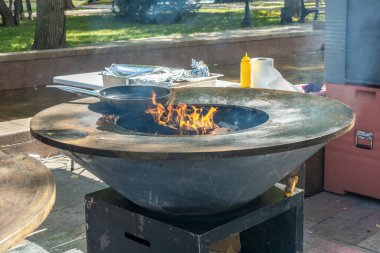 Alevli et ve sebze kızartmak için metal bir tabakla odun yakma ızgarası. Sokak yemeği.