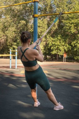 Spor sahasında egzersiz yaparken spor ipinde barfiks çeken çekici beyaz kadın. Sağlıklı yaşam tarzı