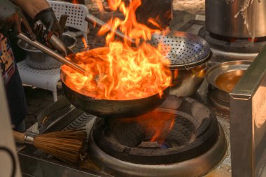 Yanan bir tencerede et ve sebzelerden Asya yemeği pişirmek. Fast food