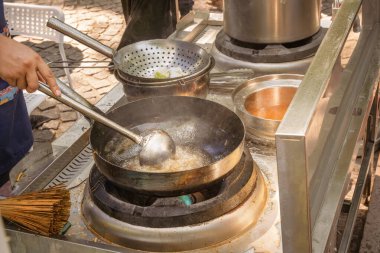 Sokaktaki bir tavada et ve sebzelerden Asya yemeği pişirmek. Fast food