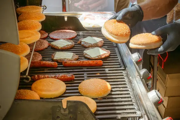 Hamburgerler ve çizburgerler için et pişirme, sosisliler için sosis, kömürlü ızgarada çörekler. Sokak yemeği.