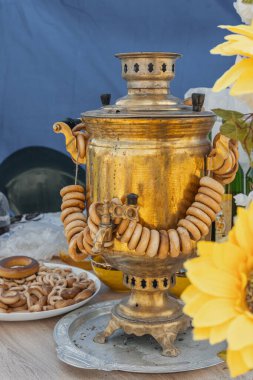 Sigara piposuyla su ısıtmak için odun yakan kazan. Simit, kraker ve çay içmek için diğer un ürünleriyle birlikte açık hava semaveri.