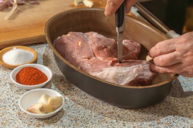 Aşçı bir parça eti sarımsak ile doldurmak için bıçak kullanır. Ev yapımı yemek.