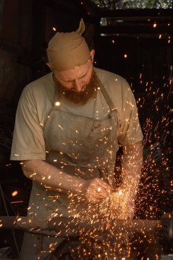 Resimli kızıl sakallı tamirci otantik bir sokak atölyesinde el testeresi ile çalışıyor..