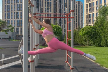 Güzel bir Asyalı kadın açık hava spor sahasında bir iple jimnastik egzersizleri yapıyor. Sağlıklı yaşam tarzı