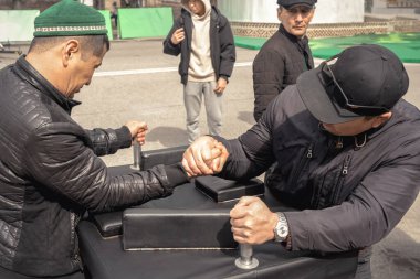 Almaty, Kazakistan - 23 Mart 2024. Şehir parkında bilek güreşi. Portre