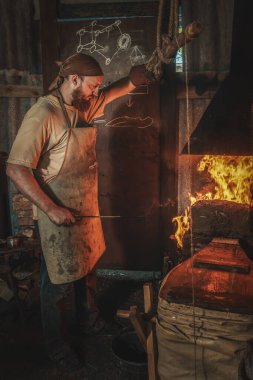 Demirci nalbantı eski bir kırsal ocakta el yapımı körüklerle tutulan bir yangını sever. Geleneksel el sanatları