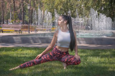 Güzel Asyalı kız parkta çimlerde yoga yapıyor. Fitness. Sağlıklı yaşam tarzı