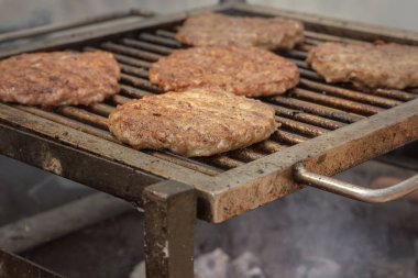 Burger bifteği sıcak kömürde pişirilir. Yakın plan.