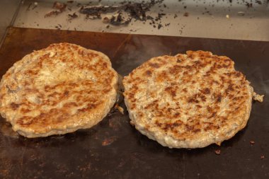 Burger bifteği sıcak kömürde pişirilir. Yakın plan.