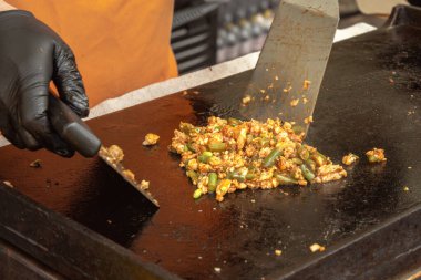 Soğanlı ve sebzeli et parçaları pita ekmeği, sandviç veya burrito için metal bir tabakta kızartılır. Sokak yemeği. Fast food. Yakın plan.