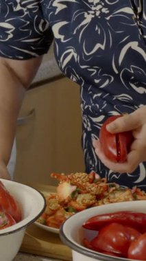 Kırmızı dolma biberden çekirdek ve tohumları çıkarmak için bıçak kullanan kadın.. 