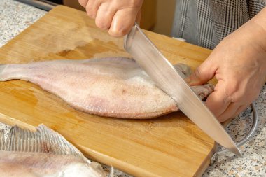 Şef taze balıkları bıçakla parçalara ayırır.