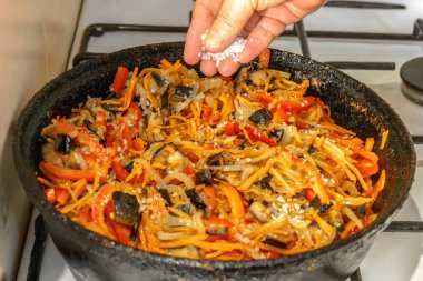 Şef tuzu, eski dökme demir tavada sebzeli kızarmış patlıcan. Patlıcan havyarı. Yemek pişirme