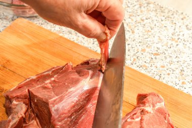 Şef, filmi bir bıçakla çiğ etle keser. Yakın plan. Yemek pişirme