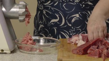 Kıyma makinesinden kıyma çıkar ve cam bir tabağa düşer. Yemek pişirme