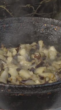 Şef eski dökme demir tavada patlıcan kızartıyor. Yakın plan.