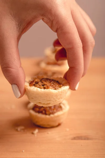 Tahta arka planda fındıklı ev yapımı mini cevizli turta.