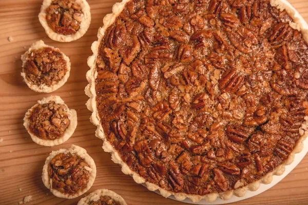 homemade pecan pie with nuts on a wooden background