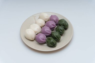 Lezzetli görünümlü üç renkli ballı pirinç kekleri bir kasede servis ediliyor.