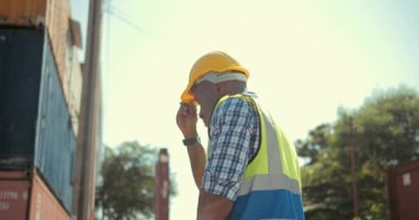 Afrikalı bir siyahi mühendisin sert bir kask takıp bir kargo konteynır fabrikasında güvenlik yeleği giydiği 360 'lık görüntüsü. Arka planda, depoda, güvenli bir şekilde etrafa bakın..