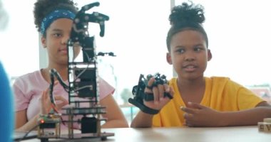 Afrikalı siyahi çocuklar okulda robotik kollarıyla oynuyorlar. Grup öğrencileri elle kontrol edilir. Teknoloji ve Yenilik kavramı.