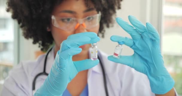 非裔美国黑人医生的手显示两种考拉病毒疫苗的选择 — 图库视频影像