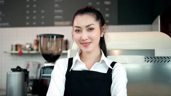 站在咖啡店目不转睛地看着相机的笑容可亲的亚洲女人的画像 — 图库照片
