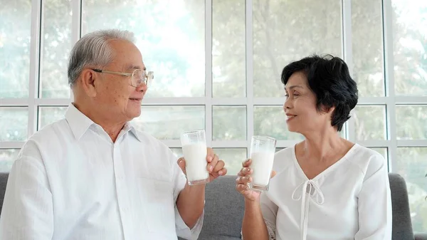 Glada Asiatiska Äldre Par Koppla Och Dricka Mjölk Soffan Hemma — Stockfoto