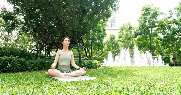Asian attractive young woman have a beautiful body, Playing yoga in an elegant posture, in the green park, concept to people recreation and health care concept