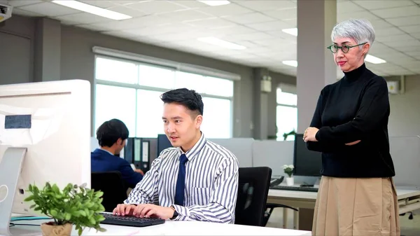 アジア人男真剣に作業上のデスクタイプのラップトップコンピュータに圧力下で簡単に彼らの上司によって立って後ろに強制的に彼らの完全な仕事 — ストック写真