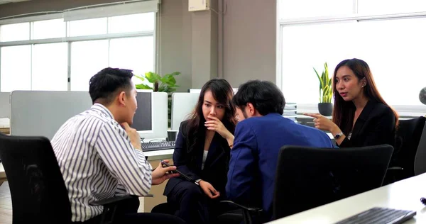 A young business diverse group chatting, gossiping and having fun in office