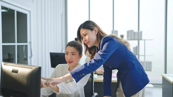 アジアの女性マネージャーが書類を再確認し オフィスでチームのスタッフと話をする — ストック写真