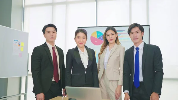 若いプロのアジア人のビジネスマンのグループが立ってカメラを見てスーツを着て — ストック写真