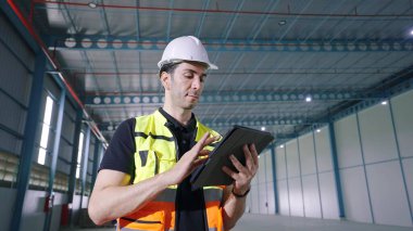 Çalışmak için tablet kullanan profesyonel beyaz erkek mimar fabrikada duran ürün düzenini veya stoğunu tekrar kontrol edin.