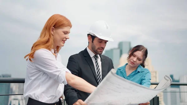 Team businesswoman and professional engineer. Open a plan to build a building in the city center from the rooftop