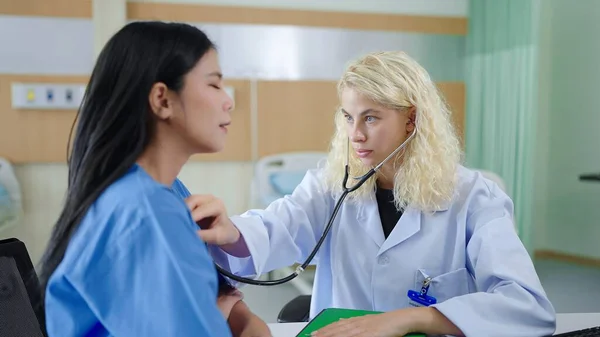 Kaukasisk Kvinna Läkare Lyssnar Patientens Hjärtfrekvens Med Stetoskop Sitter Behandlingsrum — Stockfoto
