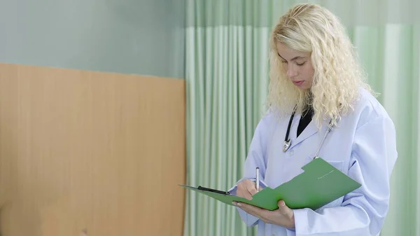 Beruf Kaukasische Ärztin Schreibt Behandlungsinformationen Auf Klemmbrett Krankenhaus — Stockfoto