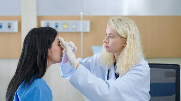 Professionell Kaukasisk Kvinna Plastikkirurg Att Injicera Asiatisk Kvinna Patientens Ansikte — Stockfoto