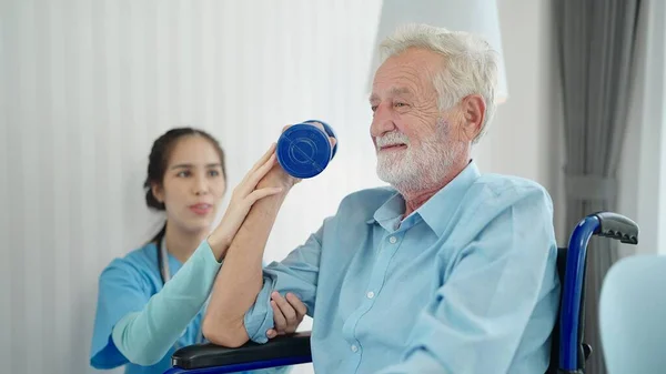 Vrouwelijke Verzorger Verpleegkundige Fysiotherapeut Helpt Oudere Man Een Rolstoel Trainen — Stockfoto