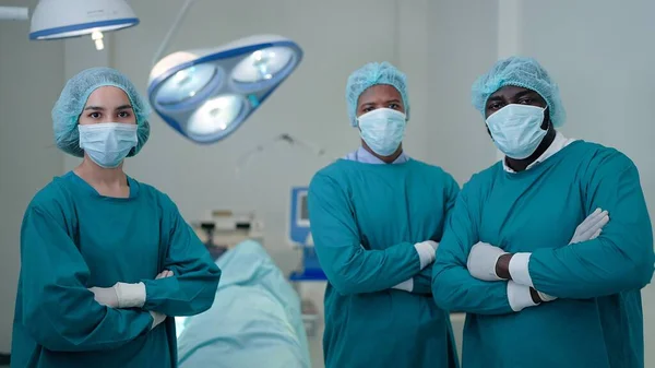 专业外科医生手挽手在镜头前交叉姿势 看起来很自信 在医院成功施行外科手术后 — 图库照片