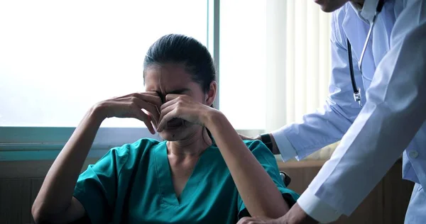 車椅子に座っている若いアジア系の落ち込んでいる女性は目を閉じてすすり泣きます 医者は話し 励まし 病院で — ストック写真