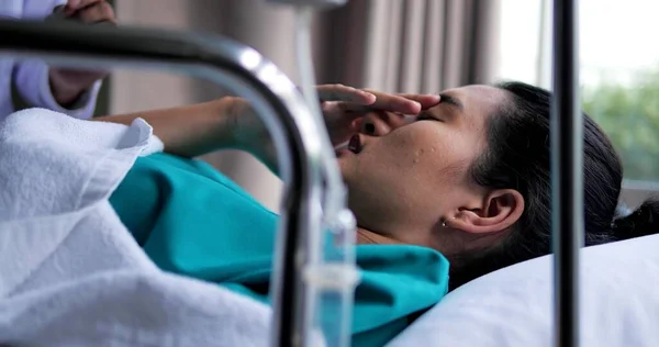 ベッドの上に寝そべっている若いアジア系のうつ病患者の女性は 病院で目と子供を閉じます 彼女は自分の健康を心配して — ストック写真