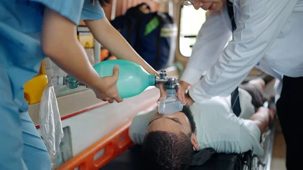 救急車の担架で負傷者のCprを行う救急車 マスクを使って呼吸する医療助手 — ストック写真