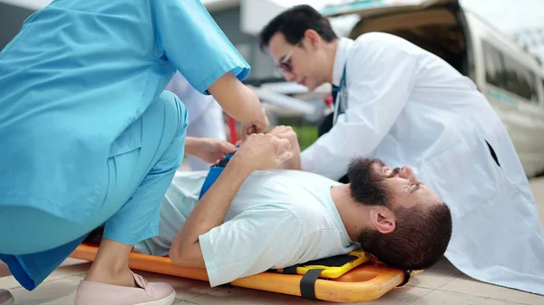 救急医療チームは ストレッチャーに横たわって負傷者に応急処置を提供します — ストック写真