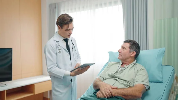 Young Doctor Describes Condition Elderly Patient Lying Bed Hospital — Stock Photo, Image