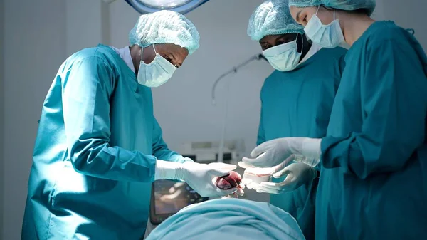 Team of surgeon doctors in operating room undergoing heart transplant surgery for patient to save life in the emergency surgical room