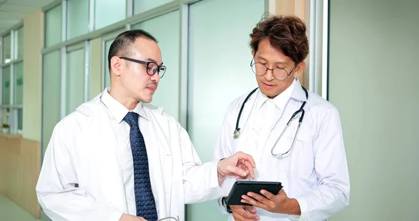 Δύο Ασιάτες Γιατροί Μιλούν Και Συζητούν Δεδομένα Διάγνωσης Των Ασθενών — Φωτογραφία Αρχείου