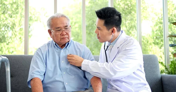 アジアの男性医師は 高齢者の患者の心を聞くために聴診器を使用します 老人ホーム訪問 高齢者の健康診断 高齢者医療支援コンセプト — ストック写真